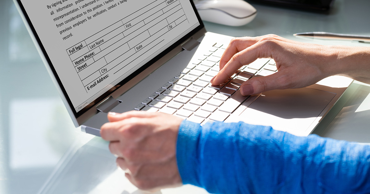 Patient using a laptop to efficiently complete a client intake form, streamlining patient onboarding.