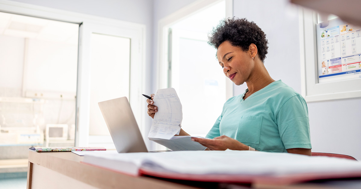 Practice staff member at her desk reviewing a medical release form to ensure patient privacy and legal compliance.